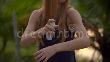 一位美丽的年轻女子在皮肤上喷洒防蚊剂的特写镜头。 热带背景